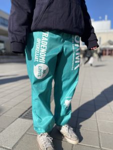 Kuva henkilöstä OAMK:in pallopihalla päällään turkoosit OUTO RY:n haalarit